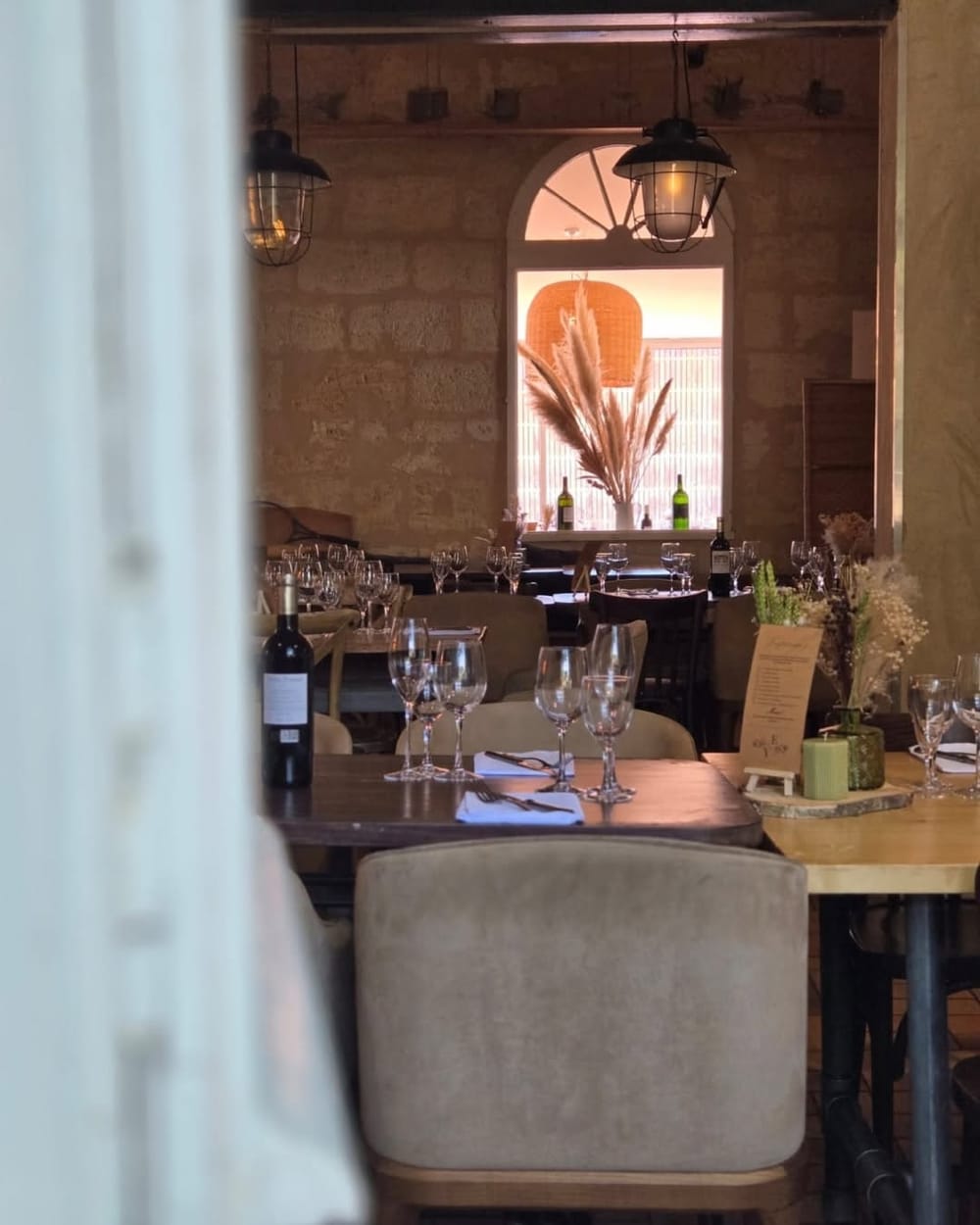 Salle du Bistrot en pierre, lanternes et tables dressées