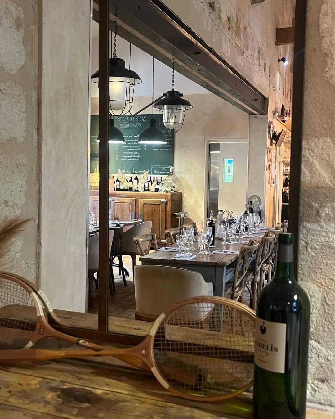 Salle du Bistrot des Girondins vue depuis la porte, tables dressées et suspensions