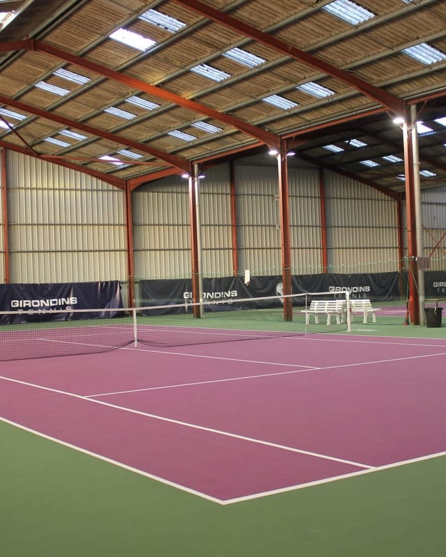 Court de tennis couvert à la surface rose, où s'entraînent les joueurs du CDHN