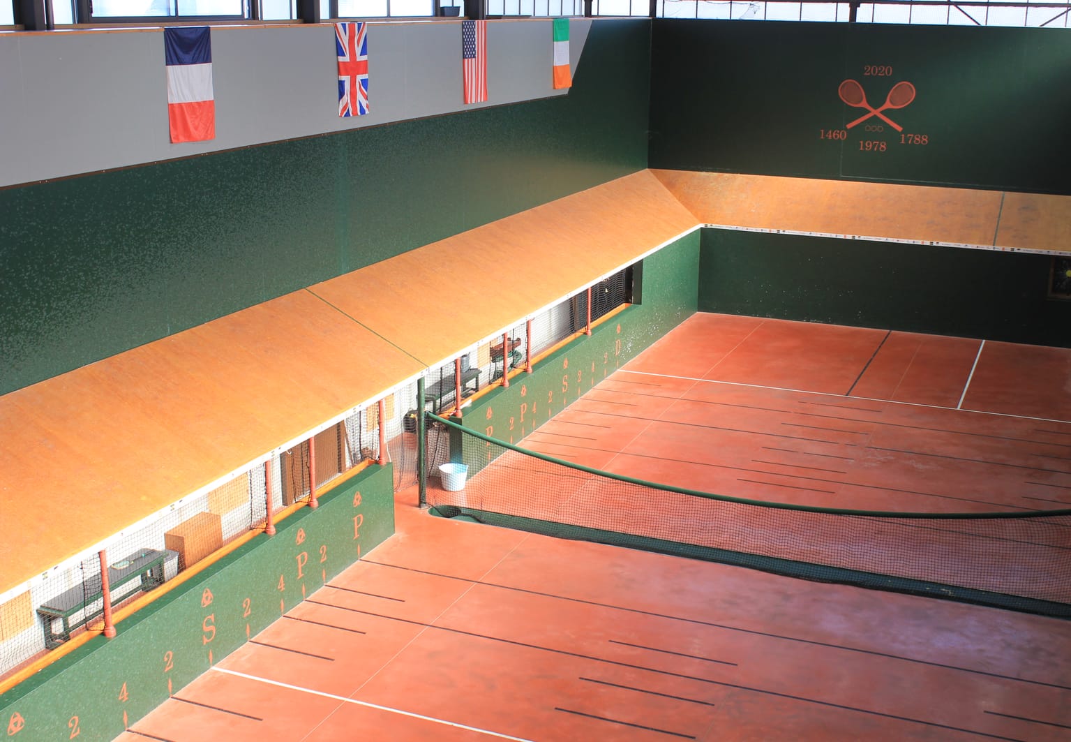 Terrain couvert de jeu de paume avec ses marquages au sol et ses drapeaux suspendus, à Mérignac